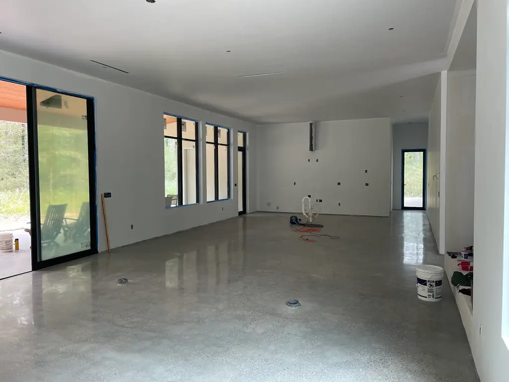 A finished satin-polished residential floor with a burnisher parked on it after the job
